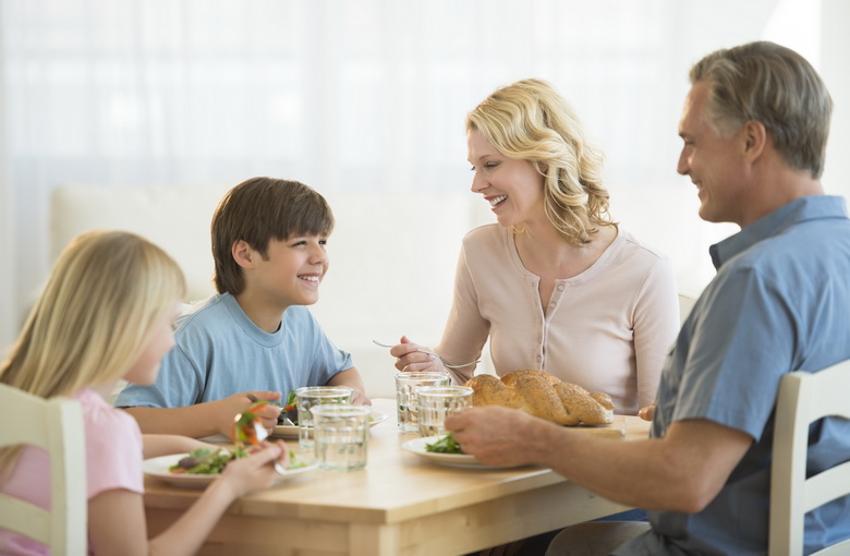 Happy family having meal together at dining table